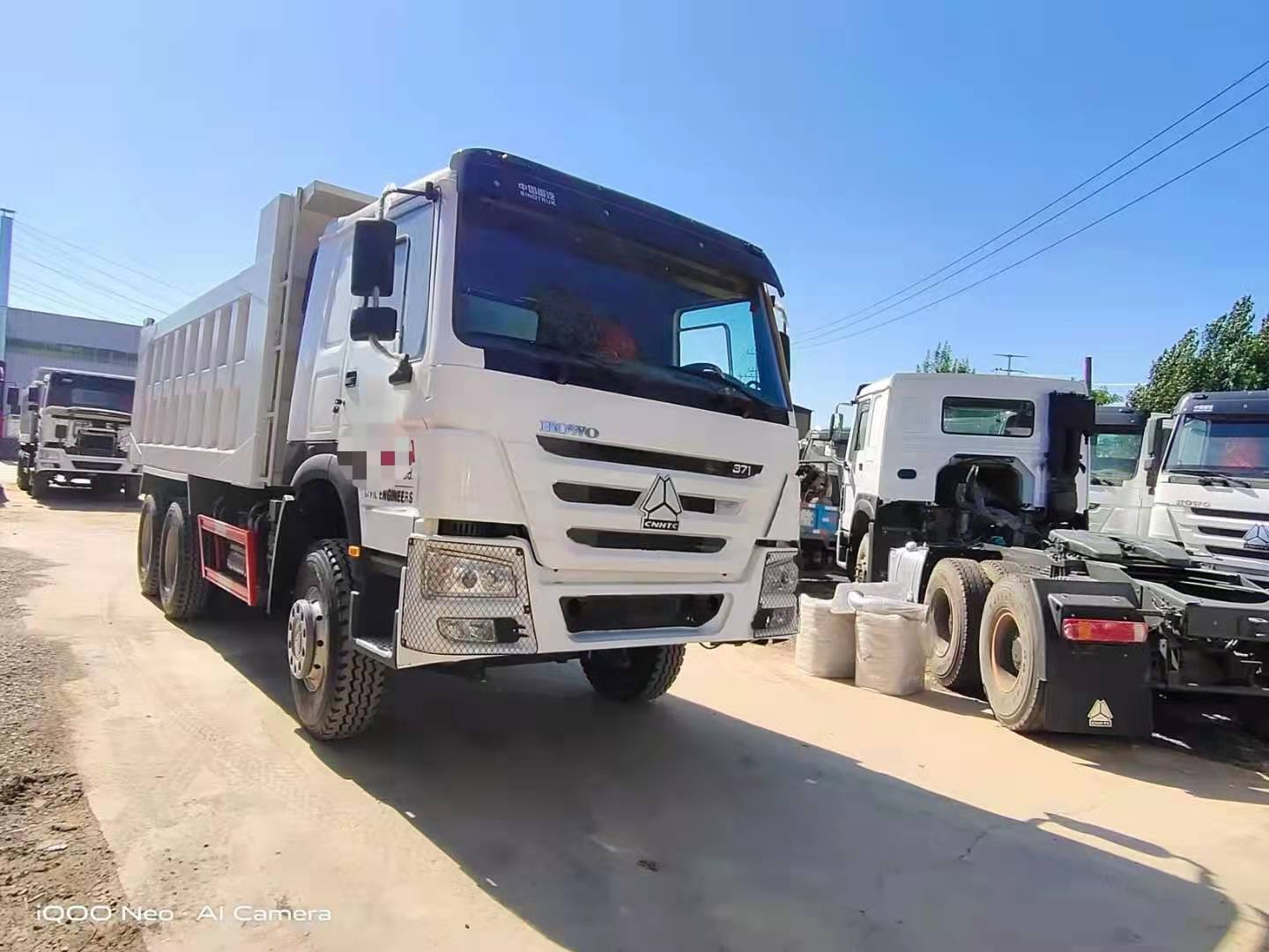 Three used dump trucks ordered by a Nigerian customer are being loaded